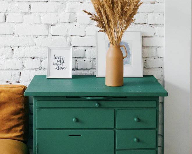 Green drawers with some decorations on them.